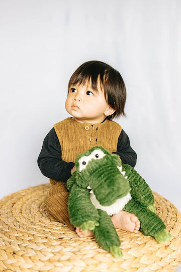 baby model holding alligator stuffed animal toy