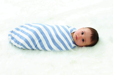 baby boy swaddled in a cotton swaddle with blue and white stripes