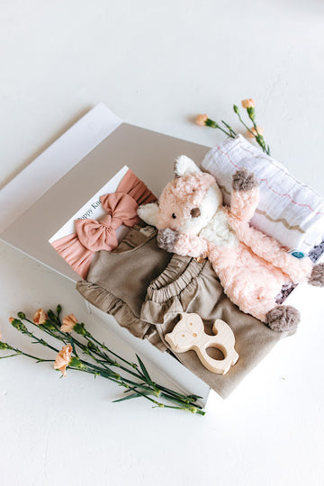 baby girl gift box with tan sweat set, blush bow headband, fox shaped wood teether, fox lovey and cotton muslin swaddle 